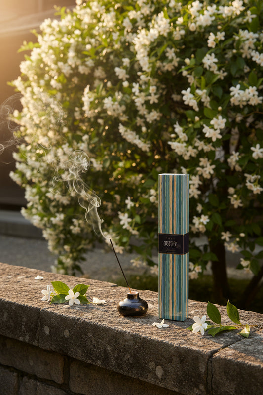 Incenso Giapponese Nippon Kodo Kayuragi Jasmine Gelsomino su muretto di pietra con cascata di fiori bianchi e incenso acceso - Erboristeria La Clessidra Carpi