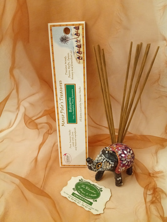 Incenso Balsamic Fiore d'Oriente Linea Marco Polo's Treasures con astuccio ben visibile, mazzetto di incensi dritti, biglietto da visita e velo sullo sfondo, esposto in negozio da Erboristeria La Clessidra Carpi.