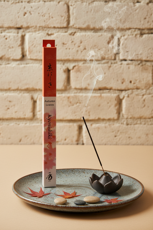Incenso Giapponese Shoyeido Daily Kyonishiki Foglie d Autunno acceso su ceramica con petali e sassi su sfondo di mattoni antichi - Erboristeria La Clessidra Carpi