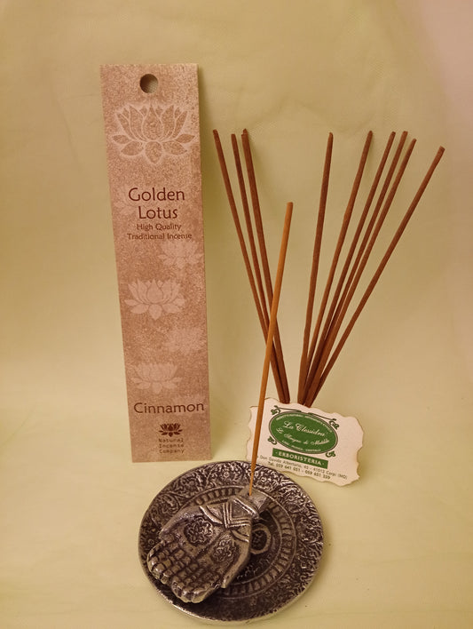 Incenso Cinnamon Cannella Fiore d'Oriente Linea Golden Lotus, astuccio con mazzetto di bastoncini aperti in piedi, portaincenso in metallo con mano e biglietto da visita esposti da Erboristeria La Clessidra Carpi.