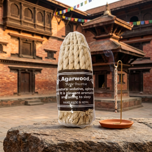 Incenso a corda nepalese Agarwood (legno di Oud), su una roccia con portaincenso e architettura Newari sullo sfondo