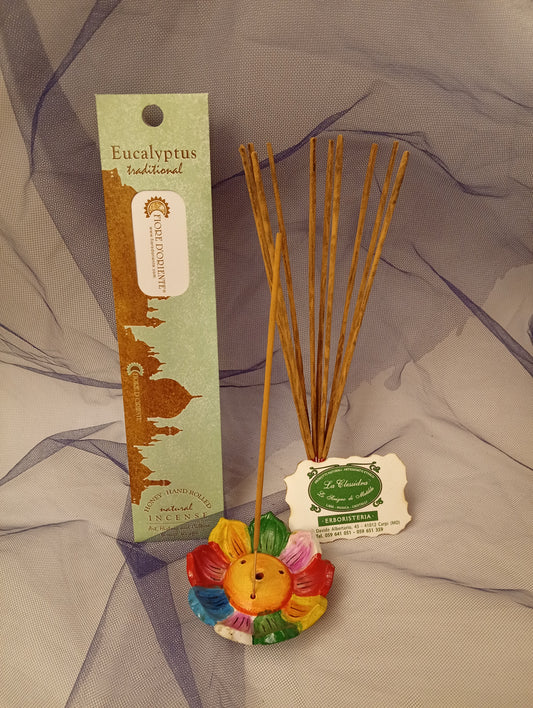 Incenso Eucalyptus Eucalipto Fiore d'Oriente Linea Traditional con stick acceso in portaincenso di ottone, cortecce e fiori su base di pietra e muro antico, da Erboristeria La Clessidra Carpi