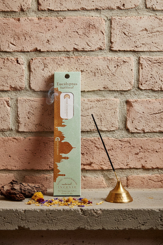 Incenso Eucalyptus Eucalipto Fiore d'Oriente Linea Traditional con stick acceso in portaincenso di ottone, cortecce e fiori su base di pietra e muro antico, da Erboristeria La Clessidra Carpi