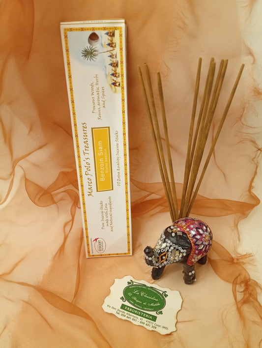 Incenso Benzoin Siam Fiore d'Oriente Linea Marco Polo's Treasures con astuccio ben visibile, mazzetto di incensi reali, biglietto da visita e velo sullo sfondo, esposto in negozio da Erboristeria La Clessidra Carpi.