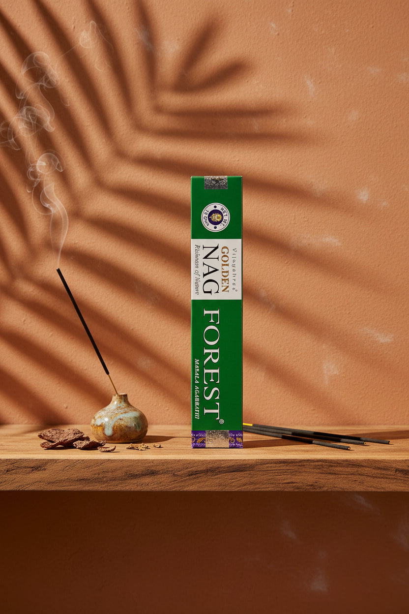 Astuccio di Incenso Golden Nag Forest Vijayshree su mensola di legno grezzo davanti a parete terracotta con ombre di foglie di palma, portaincenso artigianale con stick e scaglie di corteccia, da Erboristeria La Clessidra Carpi