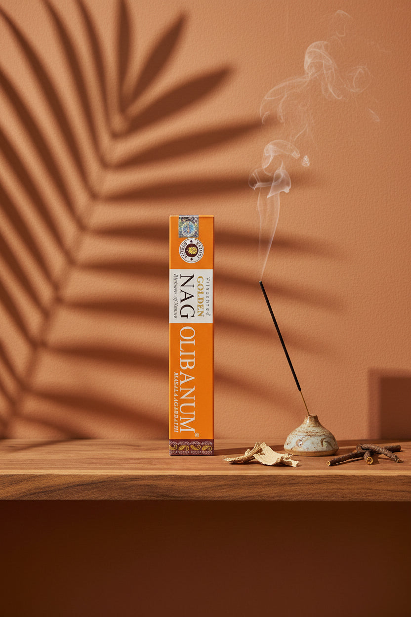 Astuccio di Incenso Golden Nag Olibanum Vijayshree su mensola di legno grezzo davanti a parete terracotta con ombre di foglie di palma, portaincenso artigianale con stick e scaglie di corteccia, da Erboristeria La Clessidra Carpi