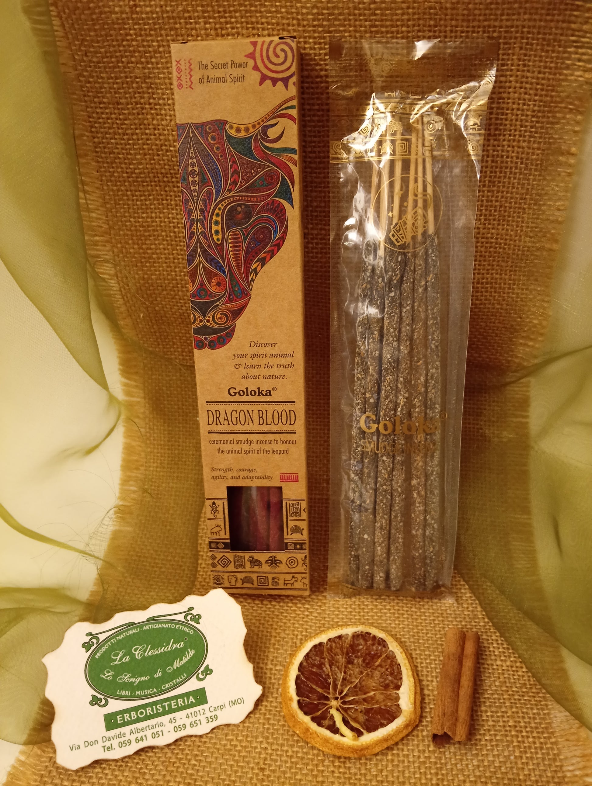 Incenso Goloka Dragon Blood stick visibili in trasparenza con biglietto da visita, cannella e juta da Erboristeria La Clessidra Carpi.