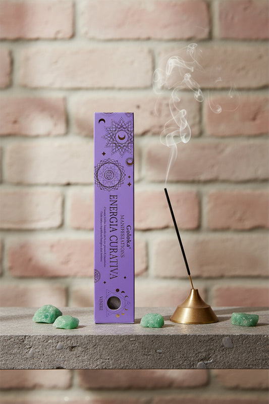 Astuccio Incenso Goloka Manifestation Energia Curativa su mensola di pietra con frammenti di Avventurina Verde, portaincenso metallico con stick acceso e muro antico, da Erboristeria La Clessidra Carpi.