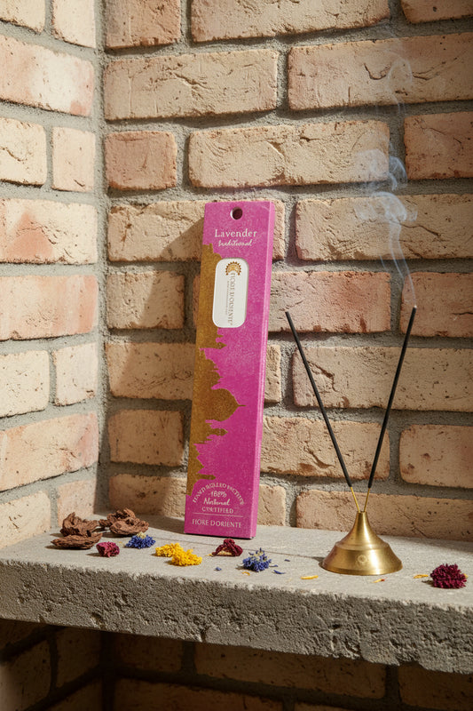 Incenso Lavender Lavanda Fiore d'Oriente Linea Traditional con stick acceso in portaincenso di ottone, cortecce e fiori su base di pietra e muro antico, da Erboristeria La Clessidra Carpi.