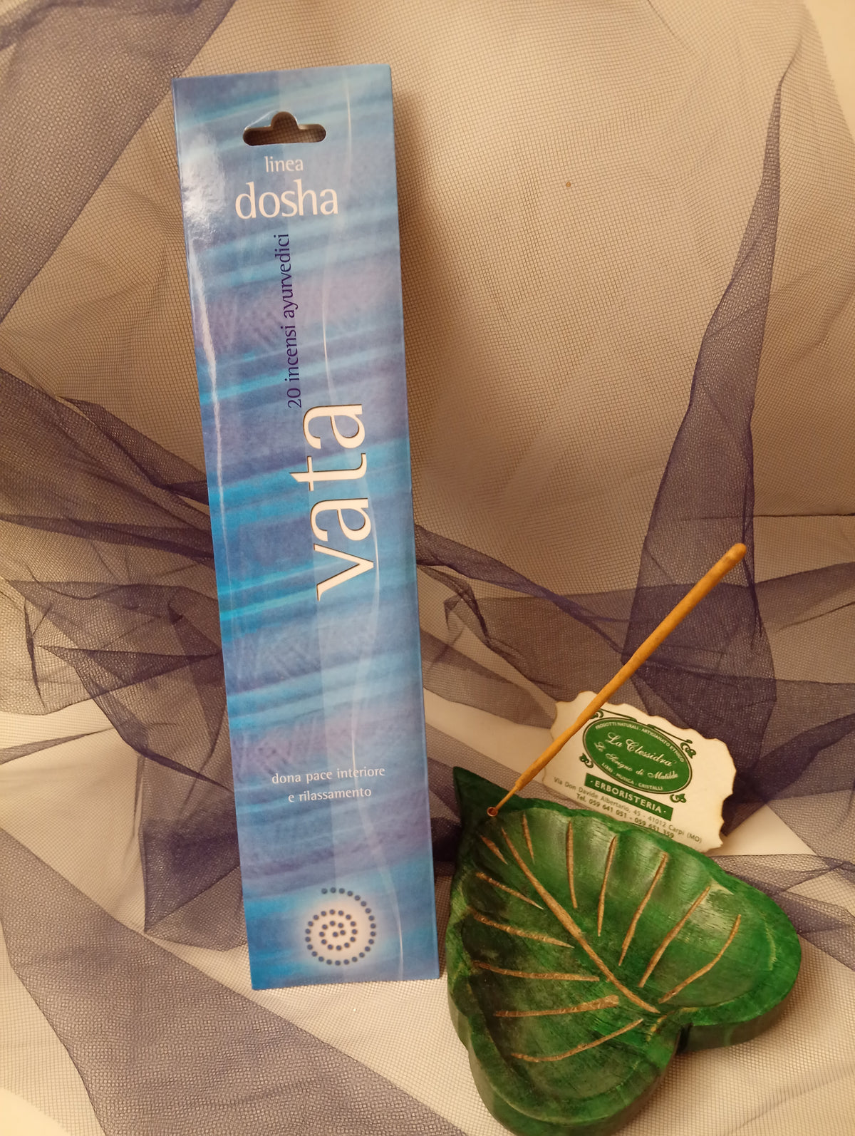 Astuccio incenso ayurvedico Linea Dosha Vata Dhanvantari con biglietto da visita La Clessidra e portaincenso a foglia su sfondo velato