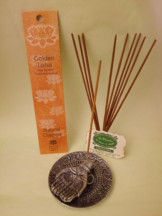 Incenso Natural Champa Fiore d'Oriente Linea Golden Lotus, astuccio con mazzetto di bastoncini aperti in piedi, portaincenso in metallo con mano e biglietto da visita esposti da Erboristeria La Clessidra Carpi.