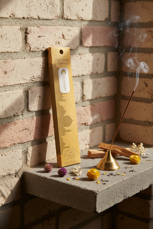 Incenso Palo Santo Fiore d'Oriente Linea Traditional con stick acceso in portaincenso di ottone, cortecce e fiori su base di pietra e muro antico, da Erboristeria La Clessidra Carpi.