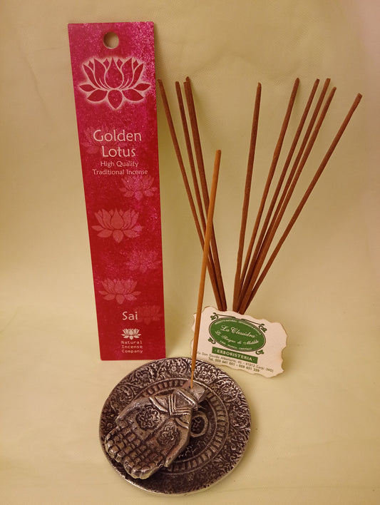 Incenso Sai Fiore d'Oriente Linea Golden Lotus, astuccio con mazzetto di bastoncini aperti in piedi, portaincenso in metallo con mano e biglietto da visita esposti da Erboristeria La Clessidra Carpi.