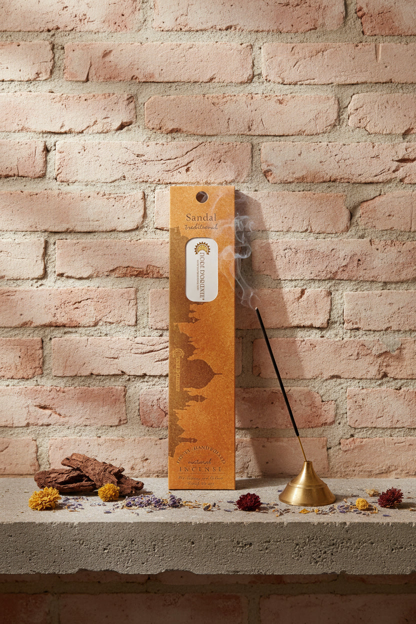 Incenso Sandal Sandalo Fiore d'Oriente Linea Traditional con stick acceso in portaincenso di ottone, cortecce e fiori su base di pietra e muro antico, da Erboristeria La Clessidra Carpi.