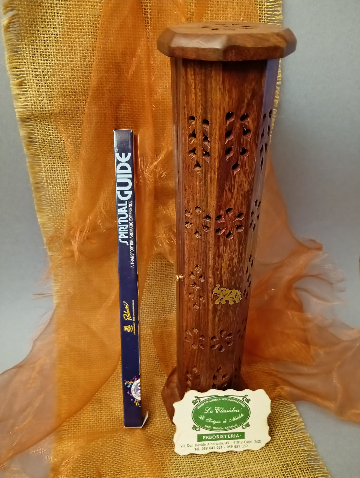 Incenso Padmini Spiritual Guide 8 stick accanto a un portaincenso in legno traforato nel negozio La Clessidra a Carpi