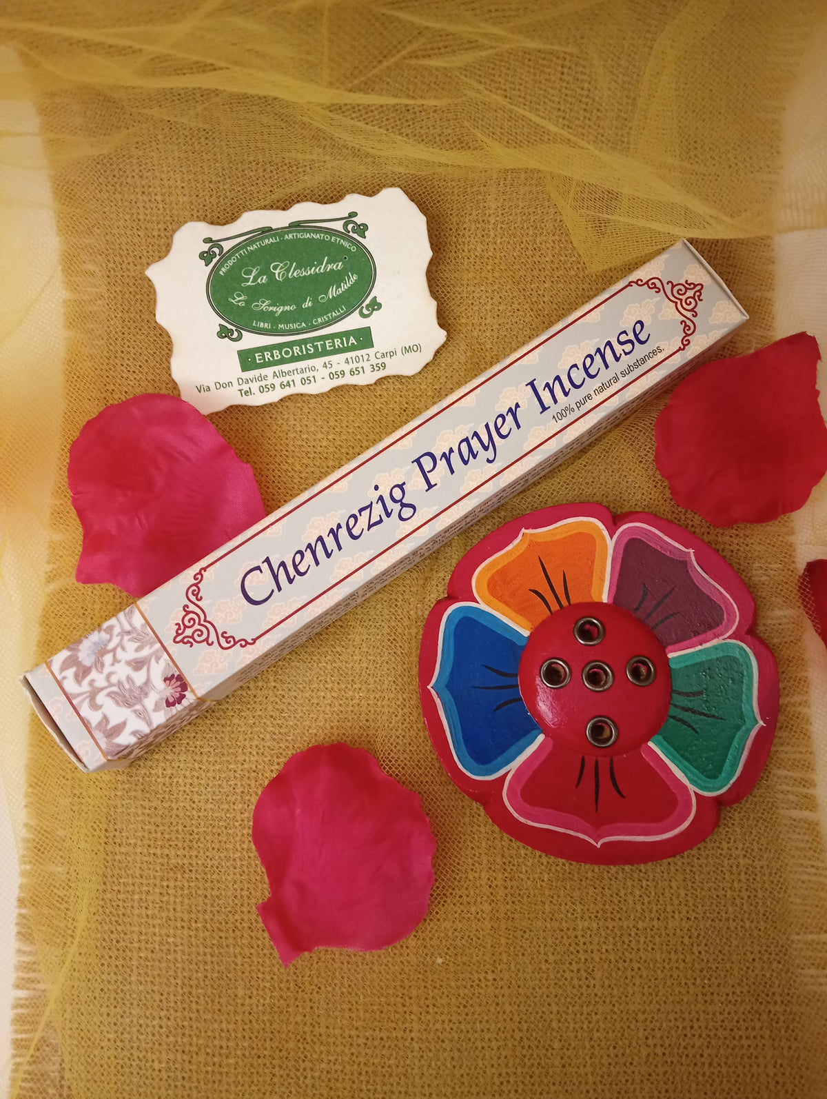 Confezione di incenso tibetano Chenrezig Prayer Himalayan Arts con portaincenso a fiore colorato, petali di rosa e biglietto di Erboristeria La Clessidra Carpi su tessuto dorato