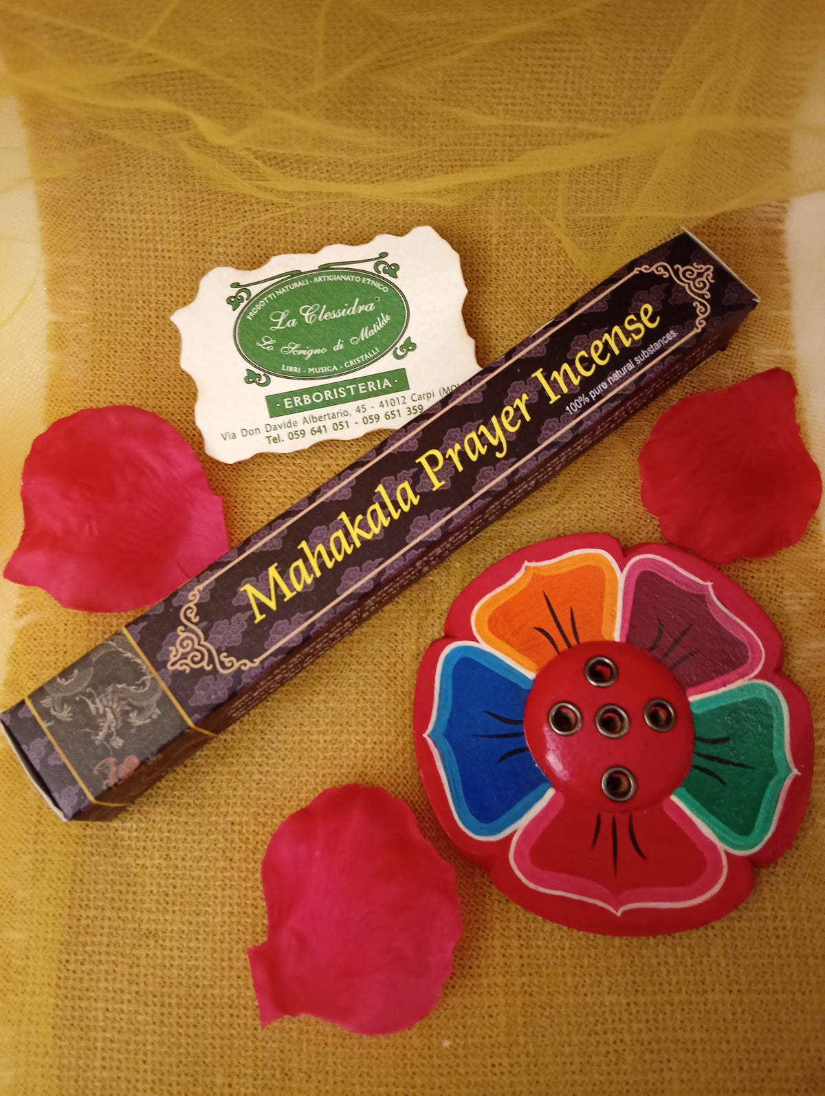 Confezione di incenso tibetano Mahakala Prayer Himalayan Arts con portaincenso a fiore colorato, petali di rosa e biglietto di Erboristeria La Clessidra Carpi su tessuto dorato