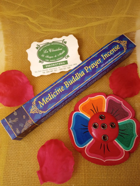 Confezione di incenso tibetano Medicine Buddha Prayer Himalayan Arts con portaincenso a fiore colorato, petali di rosa e biglietto di Erboristeria La Clessidra Carpi su tessuto dorato.